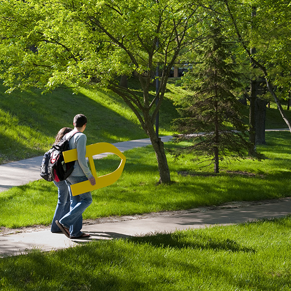 student walking with large A